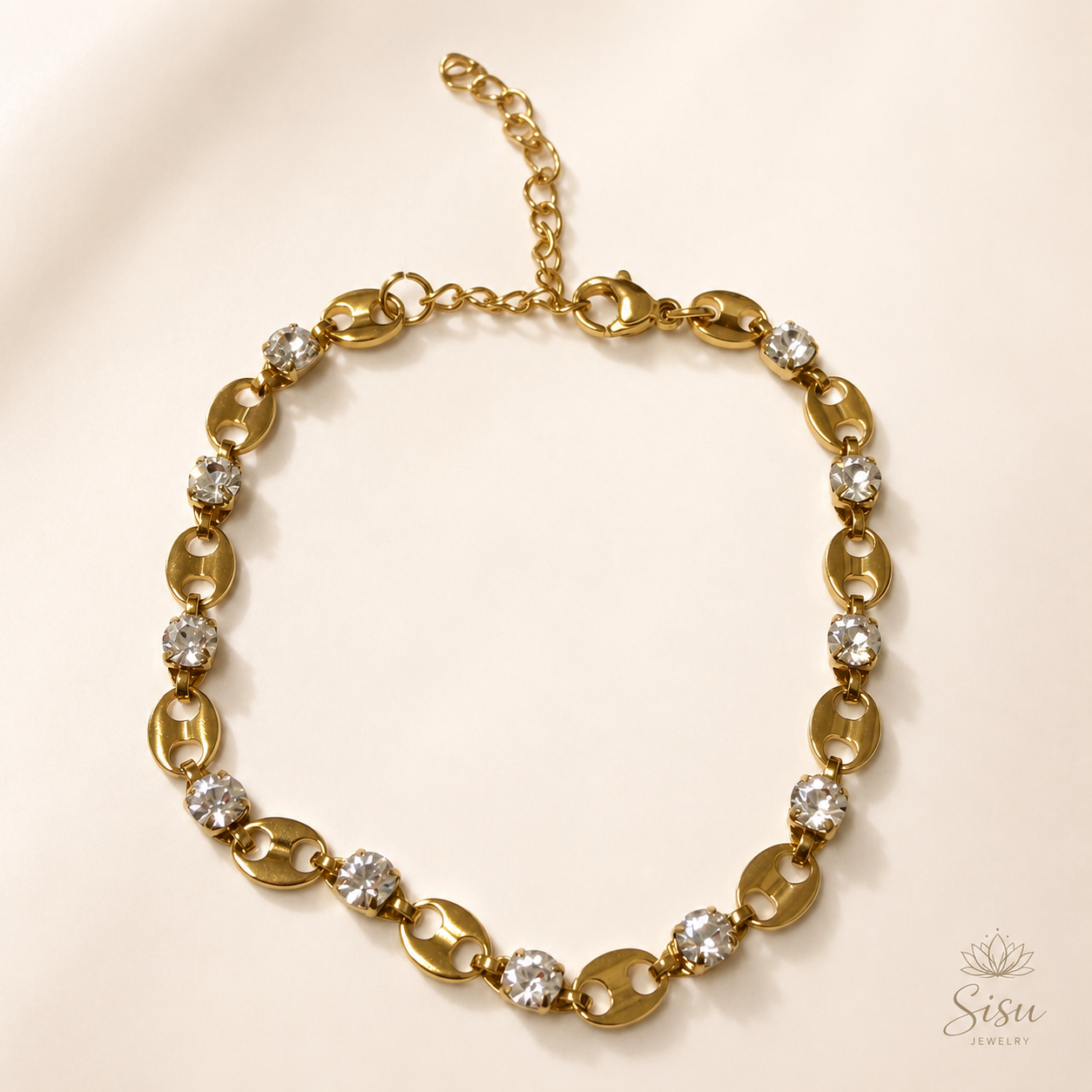 Pulsera dorada con cristales brillantes sobre fondo crema elegante de Sisu Jewelry.