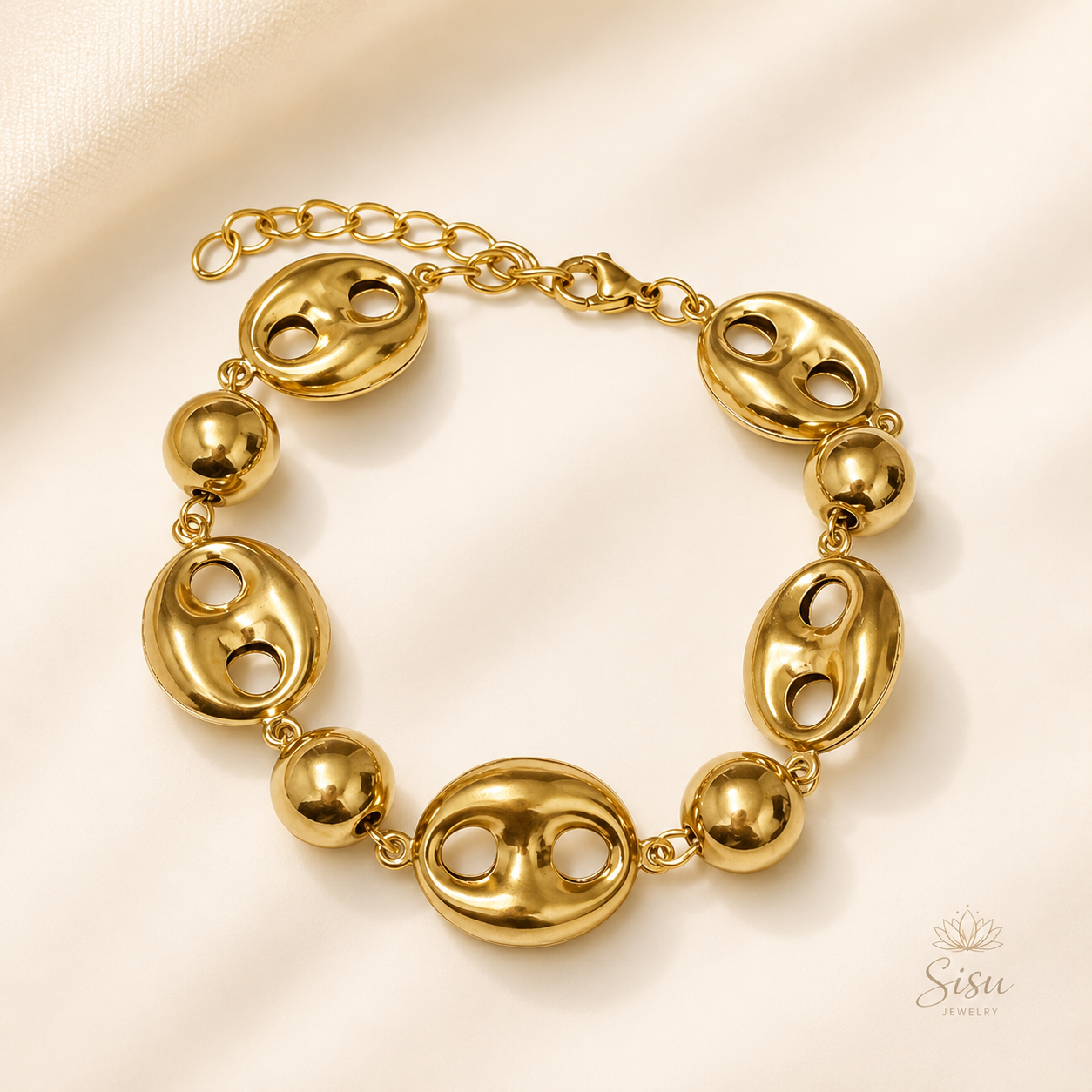 Pulsera dorada con eslabones ovalados sobre fondo crema elegante de Sisu Jewelry.
